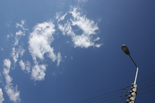 Eine Straßenlaterne auf der linken Seite mit einem bewölkten Himmel darüber.