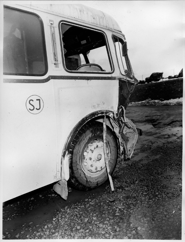 Ein Schwarz-Weiß-Foto eines alten Lkw, der auf der Seite der Straße verunglückt ist.