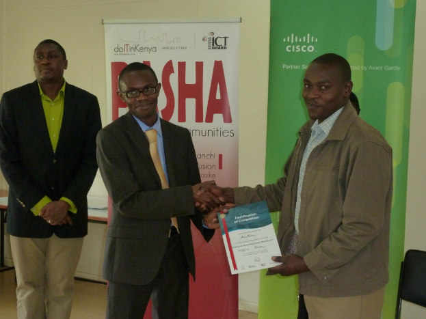 Personen mit einem Gutschein und Schildern, einem Stuhl und einem Blatt Papier im Hintergrund.