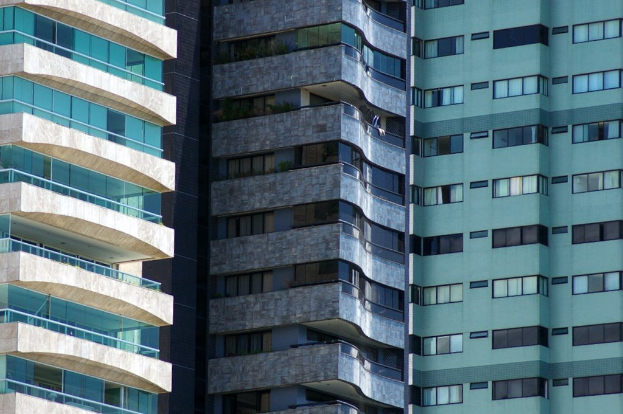 Verschiedene Gebäude in unterschiedlicher Höhe und Design sind in einer urbanen Umgebung zu sehen.