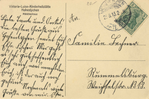 Eine alte Postkarte mit einer Briefmarke, an einen Familienmitglied aus Deutschland adressiert, mit handgeschriebener Text.