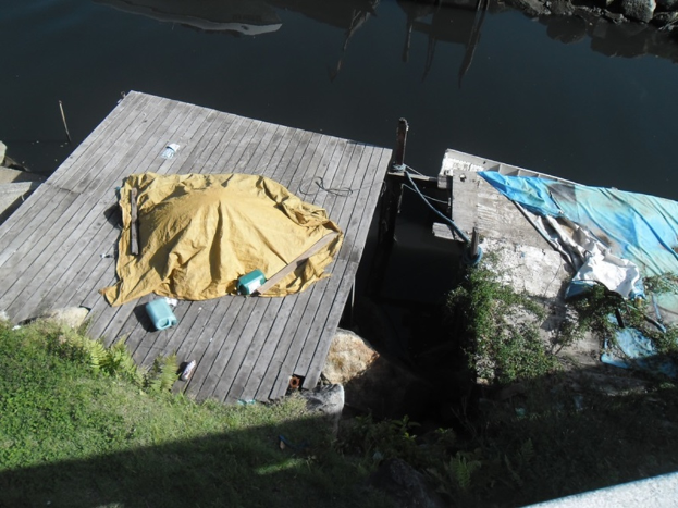 Eine hölzerne Brücke über einem See mit Gegenständen darauf.