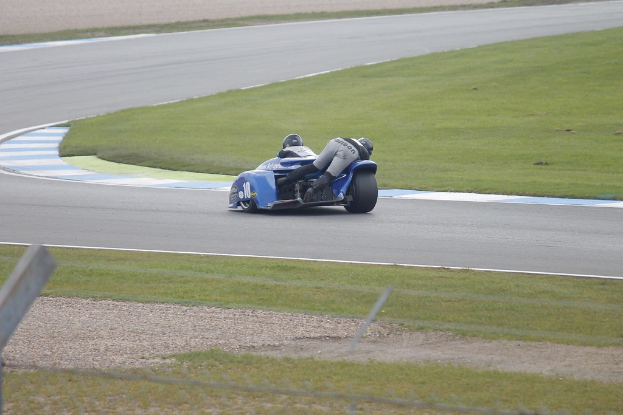 Eine Person auf einem Fahrzeug auf einer Straße mit Gras am Rand.