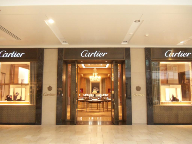 Ein Hotel mit einer Glastür in der Mitte, das einen Tisch im Inneren präsentiert.