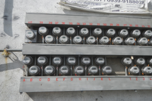 Nahaufnahme eines elektrischen Zählers an der Seite eines Gebäudes mit einem Banner über dem Text.