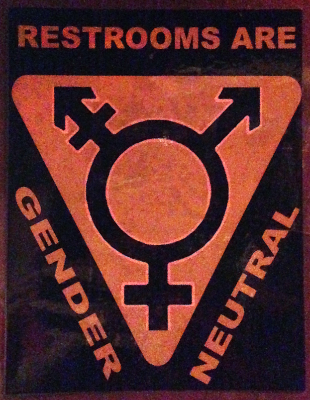 Ein Plakat mit der Aufschrift 'Toiletten sind Geschlechterneutral' betont die Bedeutung von Geschlecht auf der Toilette.