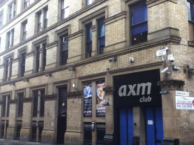 Ein Schaufenster mit Plakaten und einem Gebäude im Vordergrund.