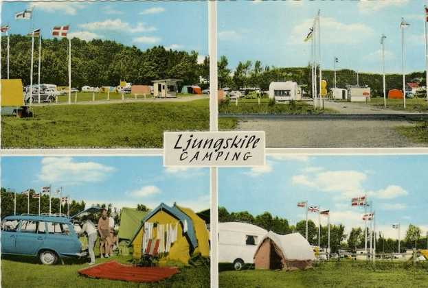 Postkarte eines Campingplatzes mit einem Auto davor, Zelten und Menschen im Hintergrund, Fahnen auf Stangen, Bäumen, einer Straße, bewölktem Himmel und einer Texttafel im Vordergrund.