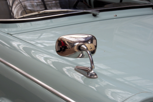 Ein Nahaufnahme eines Autos Seitenspiegels, der am Fahrzeug befestigt ist und die Umgebung reflektiert, verleiht dem Auto ein elegantes und modernes Aussehen.