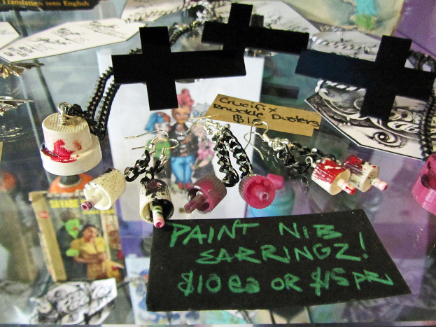 Mehrere Kreuze, Papiere und Schlüsselanhänger sind auf einem Glastisch angeordnet.