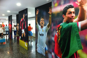 Ein Banner mit dem Fußballspieler Rolando, umgeben von Menschen an einem Tisch auf der linken Seite und Lichtern oben.