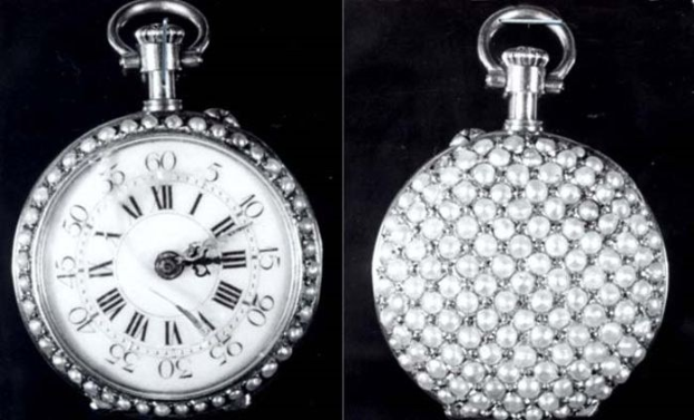 Eine silberne Taschenuhr mit Diamanten, die in einem runden Zifferblatt mit römischen Zahlen eingelassen sind, vor einem schwarzen Hintergrund.