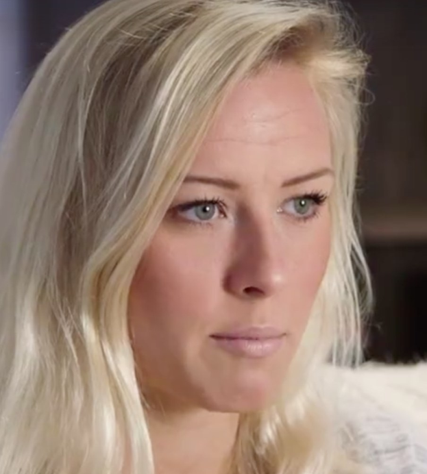 Blonde Frau mit blauen Augen in Not, Hintergrund unscharf, suggeriert erzwungenen Abgang von der Show.