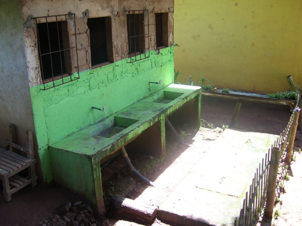 Fenster, Waschbecken und ein kaputter Stuhl sind auf der linken Seite des Bildes zu sehen, mit einer Begrenzung auf der rechten Seite.