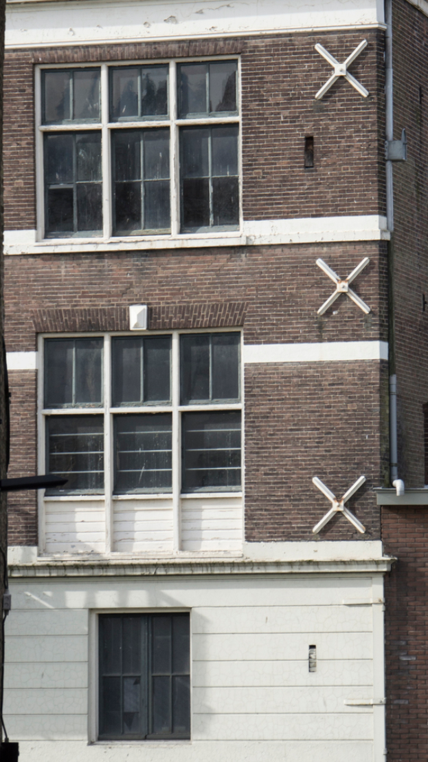 Ein Gebäude mit mehreren Fenstern und sichtbaren Rohren an seiner Außenwand.