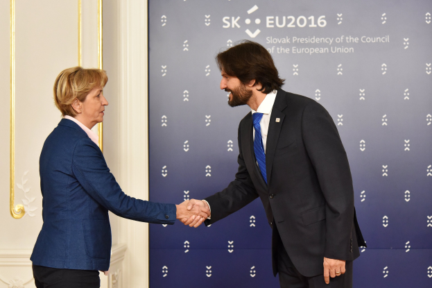 Bundeskanzlerin Angela Merkel und Bundespräsident Joachim Gauck geben sich die Hand vor einem Banner mit der Aufschrift "EU-Gipfel".