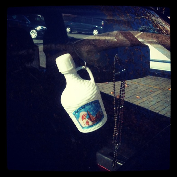 Ein Auto parkt auf einer Straße mit einer Kette und einer Flasche in der Nähe.