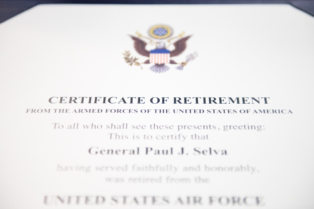 Rahmenurkunde für den Ruhestand der United States Air Force mit blauem Rand, die ein zentrales Sternemblem innerhalb eines Lorbeerkranzes und eine 'Ruhestand'-Banderole zeigt.
