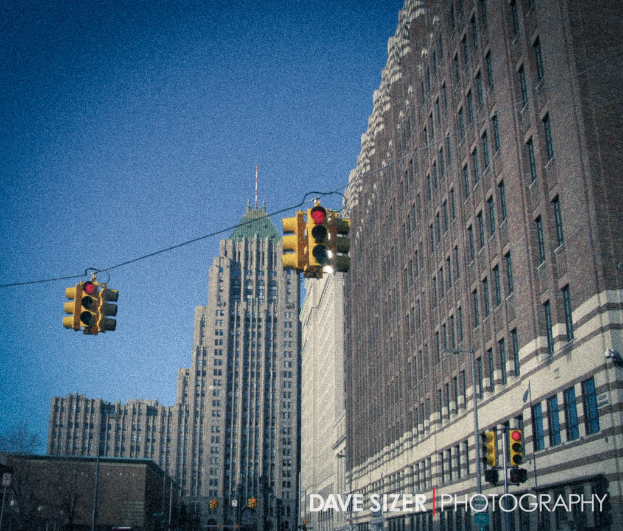 Mehrere Ampeln an Masten vor Gebäuden montiert.