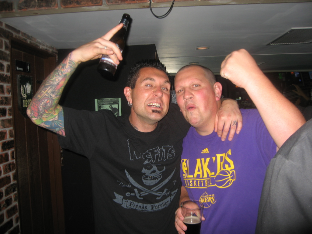 Eine Gruppe von Menschen mit einem Mann auf der linken Seite, der ein Bier hält.