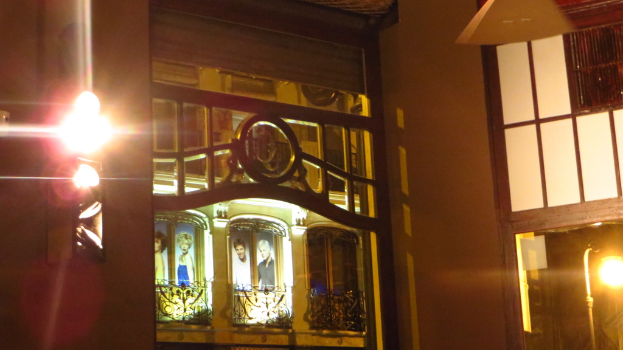 Ein Gebäude mit Gittern, Plakaten und Lichtern drum herum.