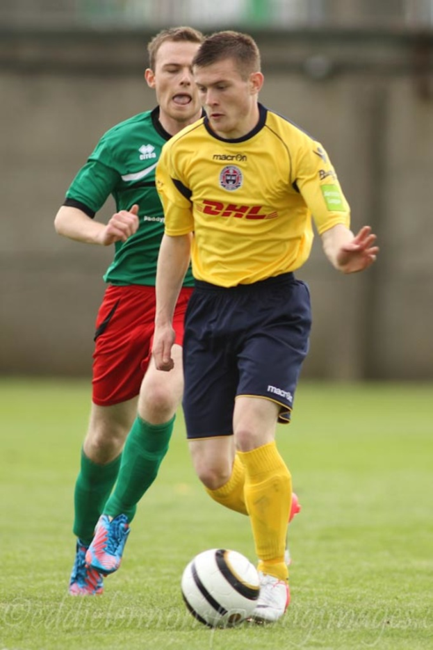 Zwei Männer beim Fußballspielen auf einem grünen Rasen mit einem Ball, mit unscharfem Hintergrund und Text unten.