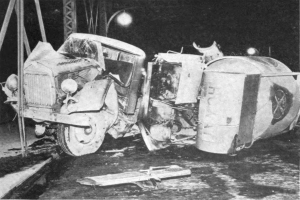 Schwarzes und weißes Foto eines umgestürzten Autos am Straßenrand mit Metallstangen und einer Straßenlaterne im Hintergrund, beschriftet mit "1930er-Jahre-Autounfall" unten.