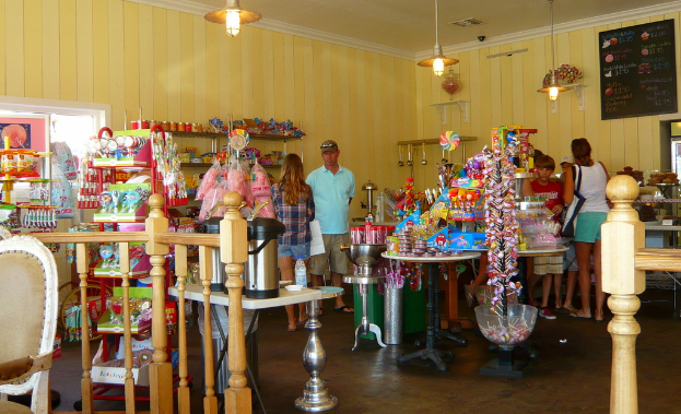 Eine Gruppe von Menschen vor einem Geschäft mit Lollis, Süßigkeiten und Backwaren.