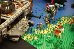 Lego-Schlossmodell mit verstreuten Lego-Teilen, einschließlich Spielzeug, Pflanzen und anderen Gegenständen.