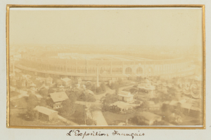 Altes Schwarz-Weiß-Foto eines Stadions in städtischer Umgebung mit umliegenden Gebäuden, Bäumen und Strommasten, mit Text am unteren Rand.