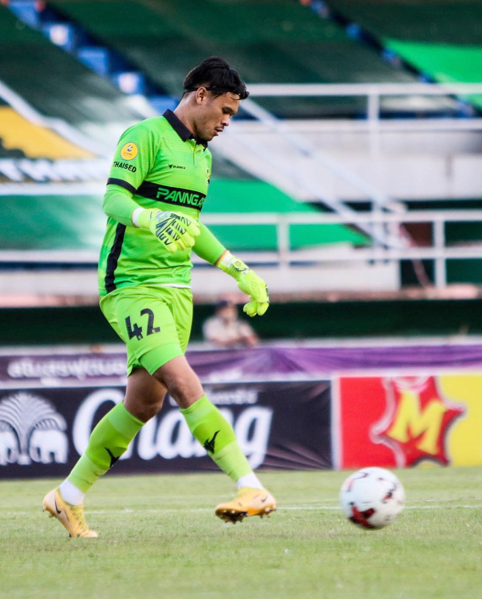 Ein Torwart in grüner Uniform kickt einen Fußball auf einem Rasenfeld während eines Matches zwischen Chivas USA und Mexico City in der Copa Libertadores, wie durch Banner im Hintergrund angezeigt.
