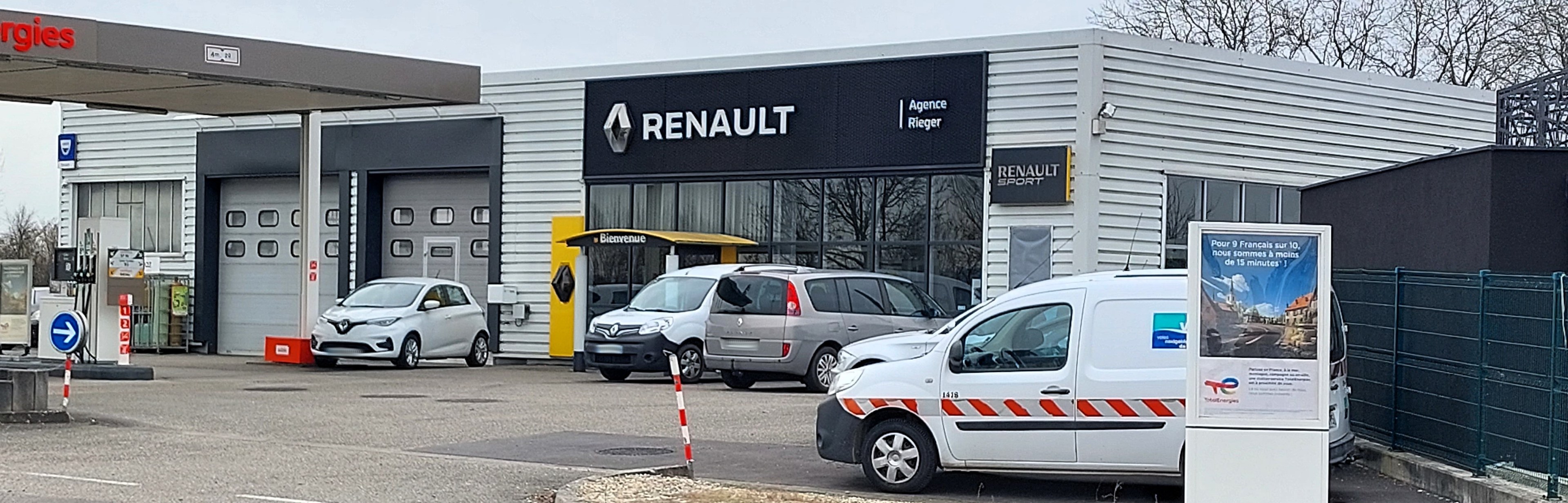 Renault-Autohaus mit parkenden Autos vorne, umgeben von einem Metallzaun.
