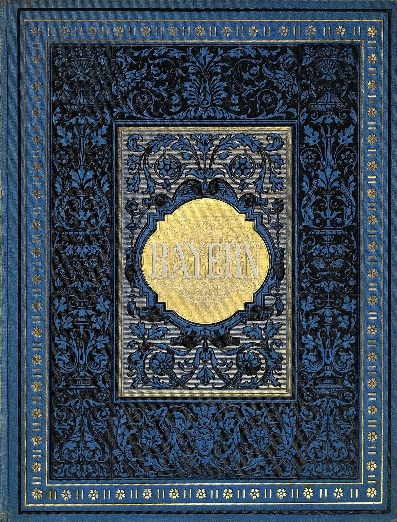 Ein blau-goldenes Buch mit dem Wort "Bayern" auf dem Cover, das dekorative Verzierungen aufweist.