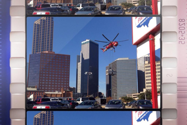 Ein Brett mit Fahrzeugen auf der Straße, Gebäuden und einem Flugzeug am Himmel.