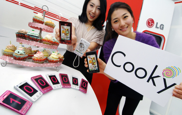 Zwei Männer präsentieren ein Mobiltelefon namens Cooky zum Verkauf, mit einem Stapel von zehn Lakh-Stücken und einigen Keksen daneben.