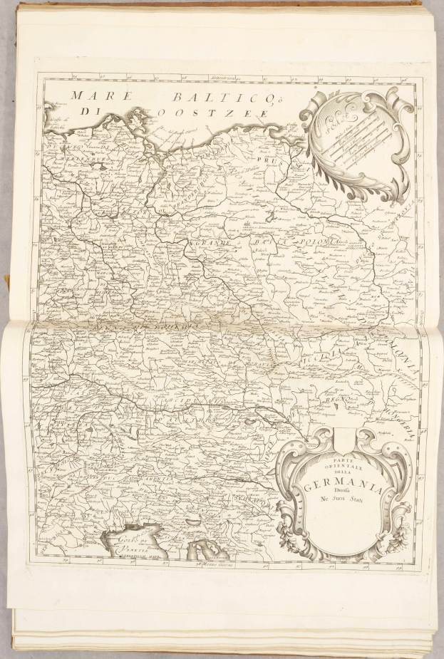 Ein altes Buch mit einer detaillierten Karte von Deutschlands Regionen auf dem Cover, begleitet von Text, der zusätzliche Informationen zur Karte liefert.