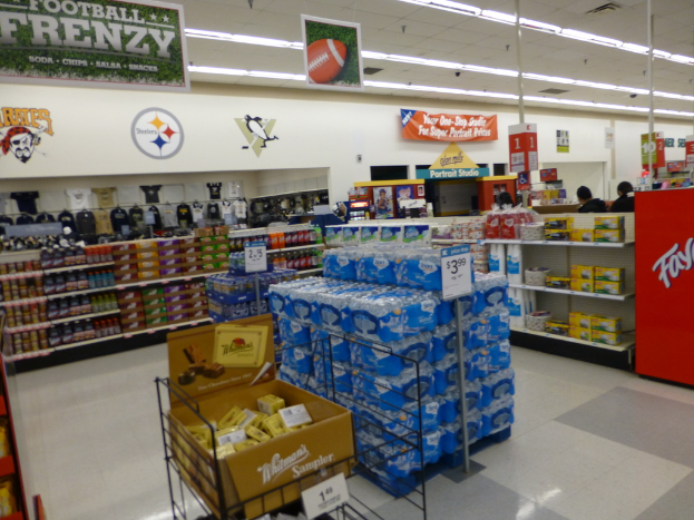 Eine Einkaufszentrumsauslage mit verschiedenen Artikeln, darunter Lampen und Plakate auf Gestellen.