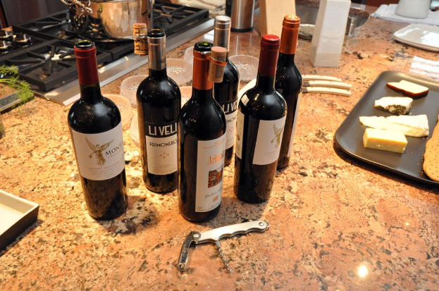 Eine Küchenplattform mit einem Topf auf dem Herd, Flaschen, ein Tablett mit Lebensmitteln, Messer, Schüsseln, einen Nagelknipser und andere Gegenstände.