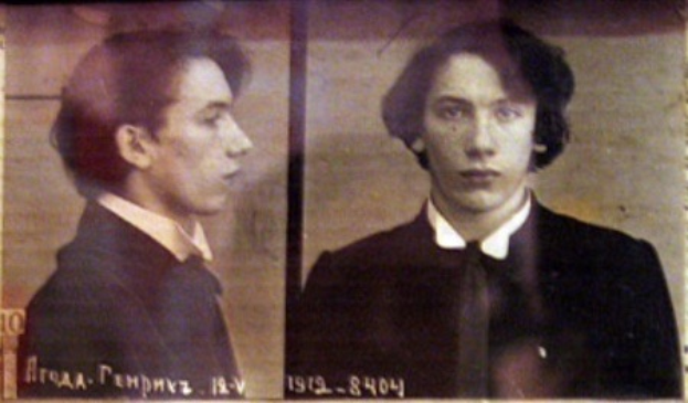 Ein Bild eines Mannes in einem schwarzen Anzug, weißem Hemd und schwarzer Krawatte mit ernster Miene und zurückgekämmtem Haar, begleitet von zwei zusätzlichen Fotos und fettgedrucktem Text, der seine Verbrechen beschreibt.