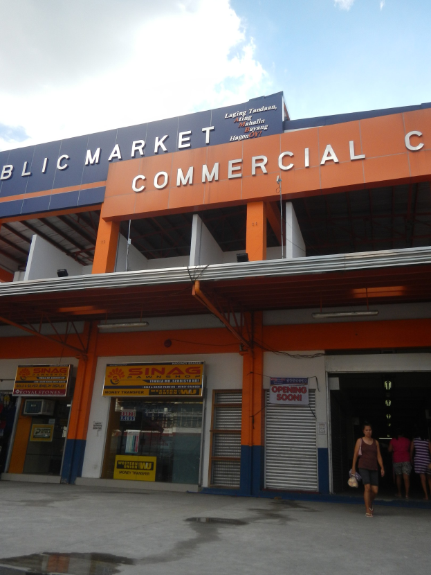Öffentlicher Markt mit Menschen vor einem Geschäftshaus, Text auf dem Gebäude und Himmel darüber