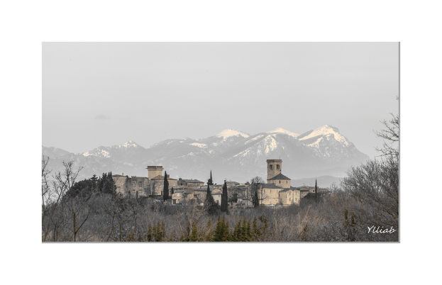 Eine Burg in der Mitte mit Bäumen unten, Hügeln und Himmel im Hintergrund.