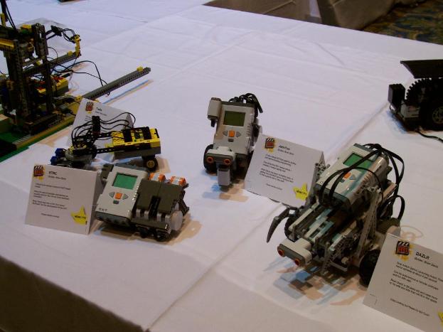 Verschiedene graue und gelbe Maschinen und Platinen liegen auf einem weißen Tuch.