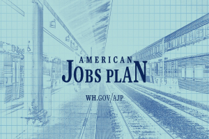 Blaupause eines Bahnhofes mit der Aufschrift "American Jobs Plan" und einem Zug auf der rechten Seite sowie Eisenbahnschienen daneben.