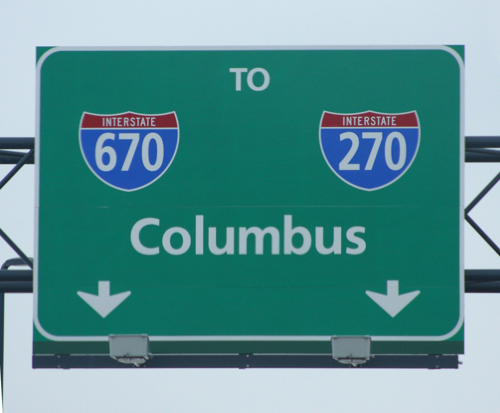 Ein grünes Schild mit Zahlen und Text auf einem Werbetafel.